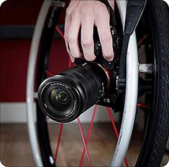 camera being held to the side of a wheelchair